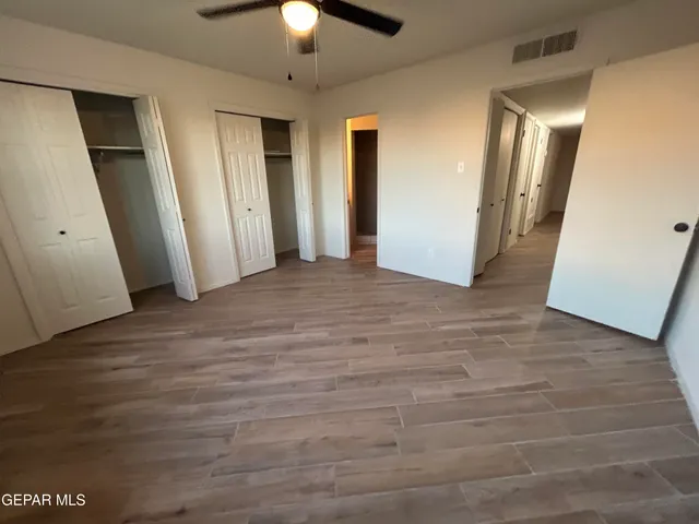 an empty room with wooden floor and staircase