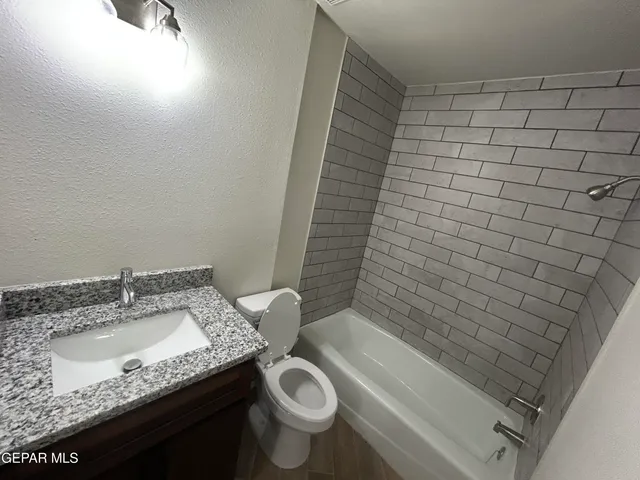 a bathroom with a granite countertop sink toilet and shower