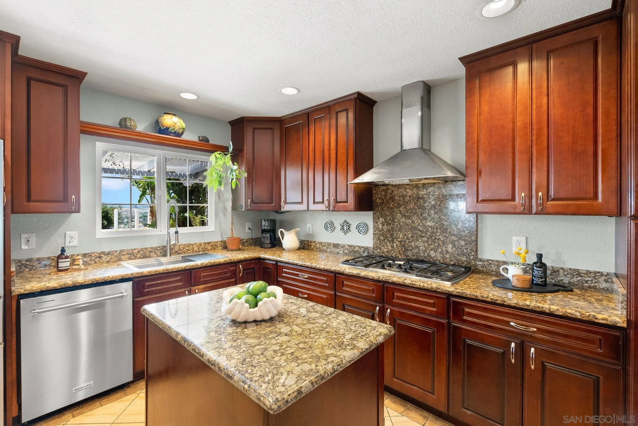 5492 Redding Road San Diego, CA 92115 - Photo 17 of 74 a kitchen with stainless steel appliances granite countertop wooden cabinets a sink dishwasher and a stove top oven