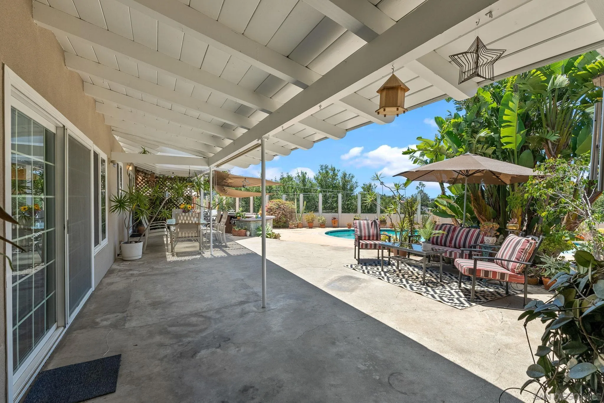 5492 Redding Road San Diego, CA 92115 - Photo 34 of 74 a view of a patio with chairs and tables with a umbrella