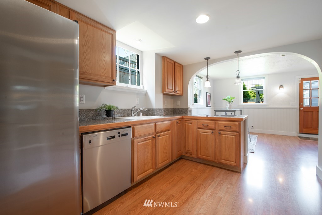 3011 West Viewmont Way West Seattle, WA 98199 - Photo 19 of 28 a kitchen with stainless steel appliances granite countertop a sink cabinets and wooden floor
