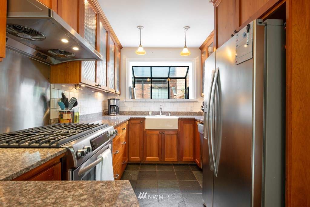 3011 West Viewmont Way West Seattle, WA 98199 - Photo 6 of 28 a kitchen with stainless steel appliances granite countertop a refrigerator a sink dishwasher a stove and a dining table with wooden floor