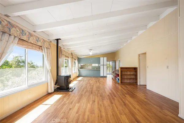 a view of empty room with wooden floor and fireplace
