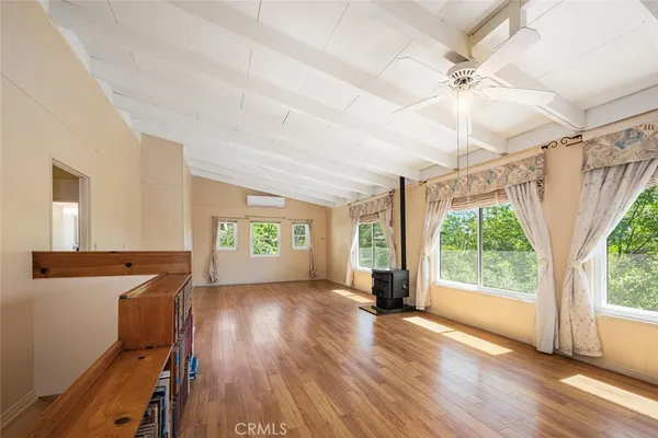 a view of a room with wooden floor fan and windows