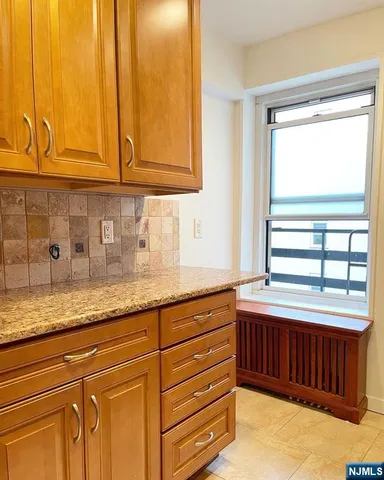 a kitchen with stainless steel appliances granite countertop a sink a stove and cabinets