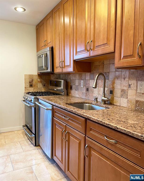 2205 North Central Road, Unit 3D Fort Lee, NJ 07024 - Photo 13 of 29 a kitchen with stainless steel appliances granite countertop a sink a stove and cabinets