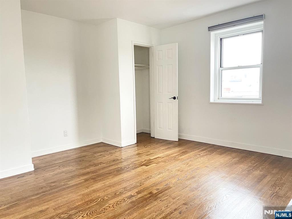 2205 North Central Road, Unit 3D Fort Lee, NJ 07024 - Photo 18 of 29 an empty room with wooden floor and windows
