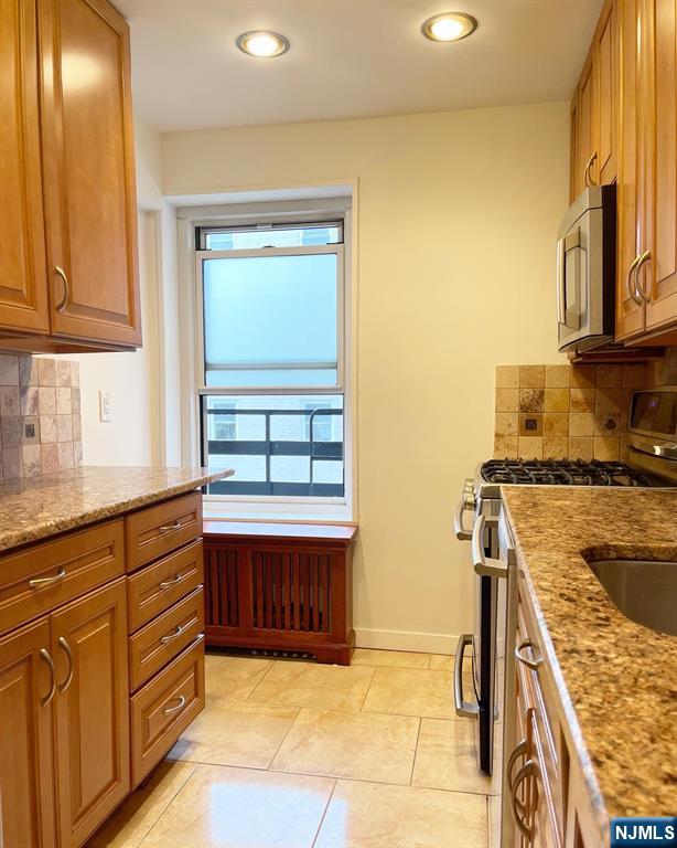 2205 North Central Road, Unit 3D Fort Lee, NJ 07024 - Photo 10 of 29 a kitchen with stainless steel appliances granite countertop a stove and a sink
