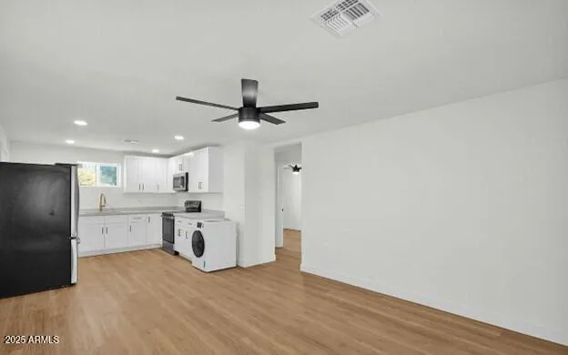 a view of a kitchen with a sink and refrigerator