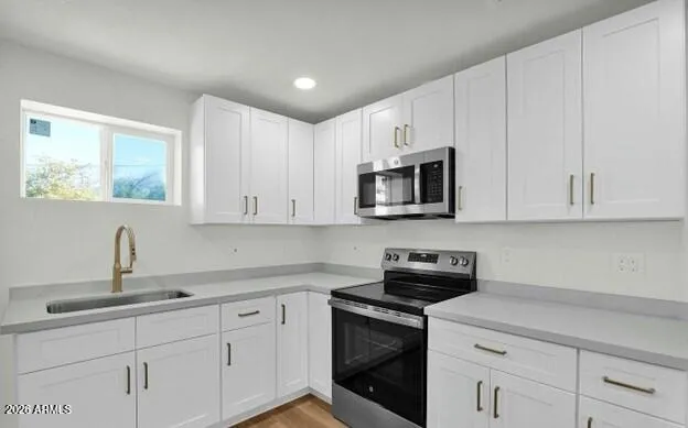 a kitchen with white cabinets and stainless steel appliances