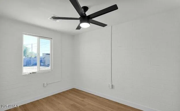 an empty room with a window and a ceiling fan