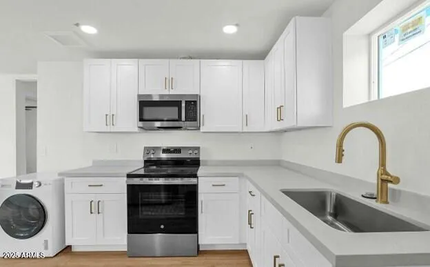 a kitchen with white cabinets and stainless steel appliances