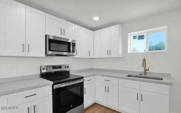 a kitchen with white cabinets and stainless steel appliances