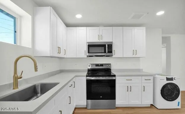 a kitchen with white cabinets and stainless steel appliances