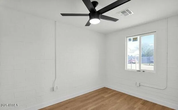 an empty room with a window and a fan