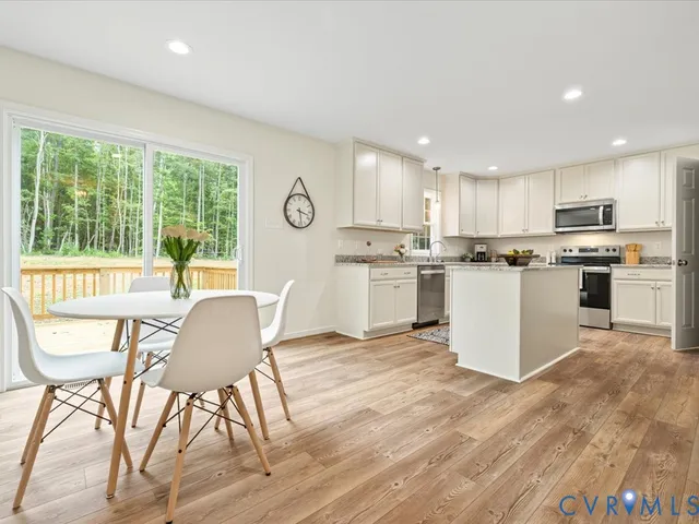 a kitchen with a table chairs a refrigerator cabinets and a dining table
