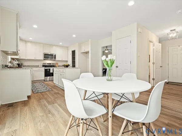 a kitchen with stainless steel appliances kitchen island granite countertop a kitchen island a stove a table and chairs