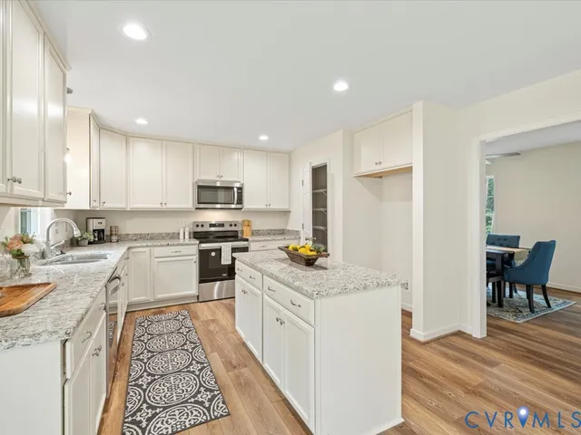 a kitchen with granite countertop a sink stove and refrigerator