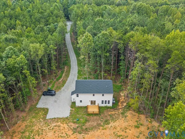 a aerial view of a house with swimming pool and trees