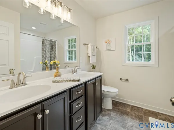 a bathroom with a granite countertop sink a toilet and a mirror