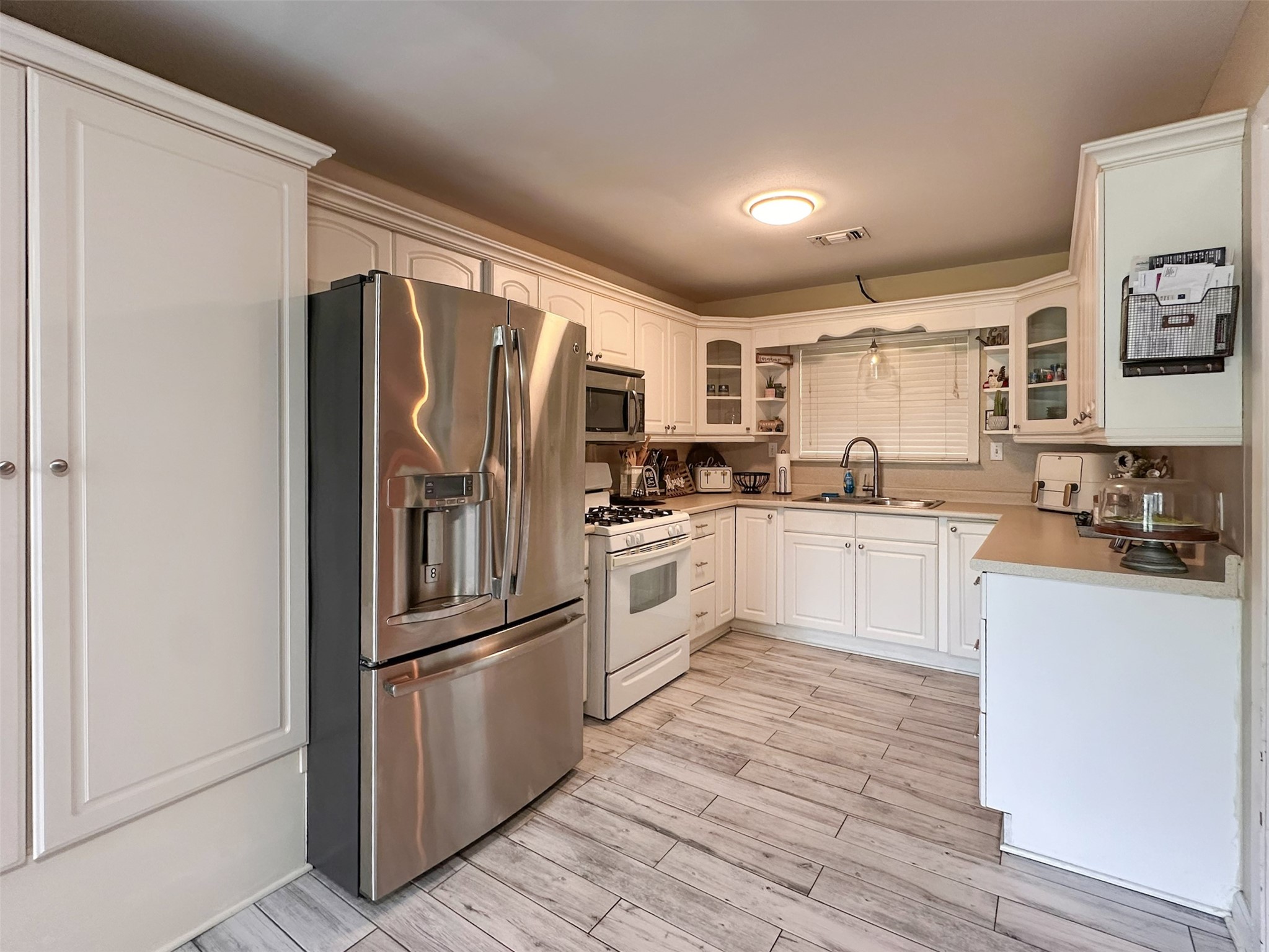 720 Northridge Street Angleton, TX 77515 - Photo 5 of 12 a kitchen with white cabinets stainless steel appliances and a refrigerator