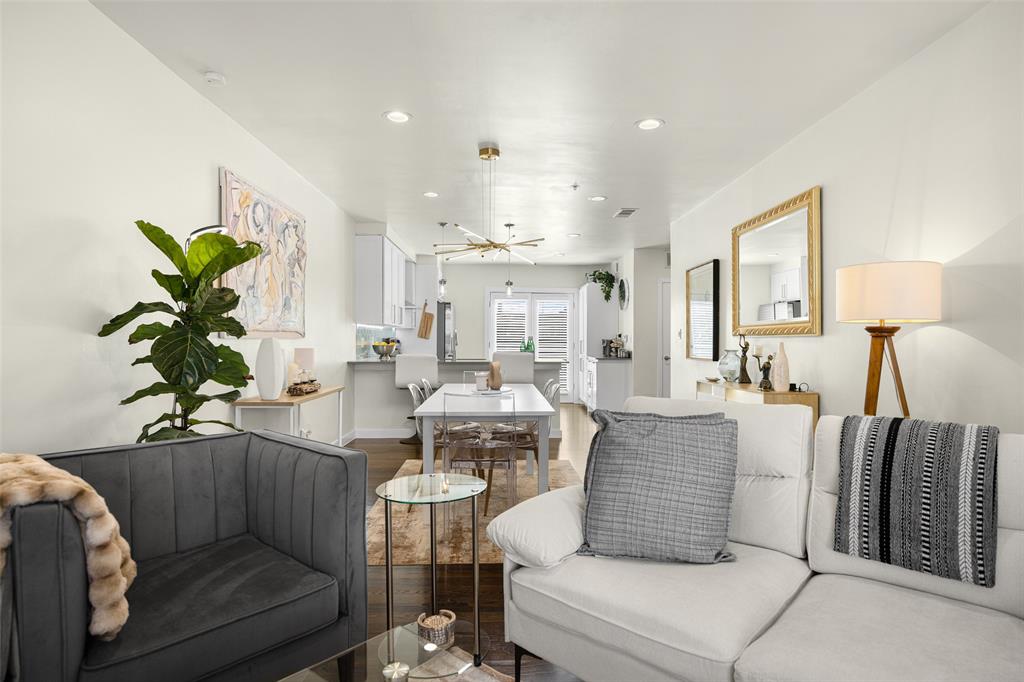 3922 Gilbert Avenue, Unit 214 Dallas, TX 75219 - Photo 8 of 27 Open-concept living area featuring recessed lighting, dark wood-finish flooring, and a dining space with a contemporary chandelier