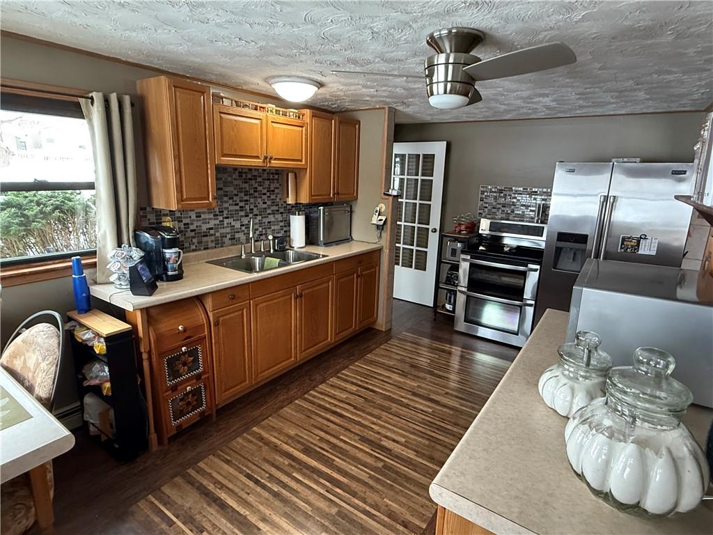 2964 McIntyre Road McIntyre, PA 15756 - Photo 16 of 29 a kitchen with stainless steel appliances wooden floors wooden cabinets a sink and a stove