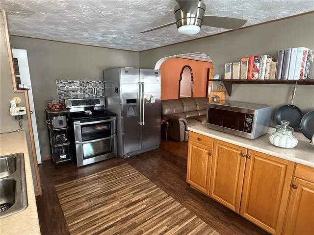 a kitchen with stainless steel appliances a stove refrigerator and microwave