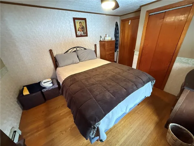 a bedroom with a bed and wooden floor
