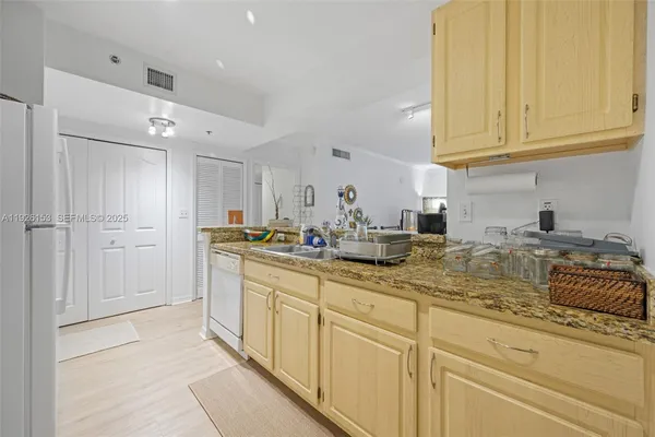 a kitchen with sink refrigerator and cabinets