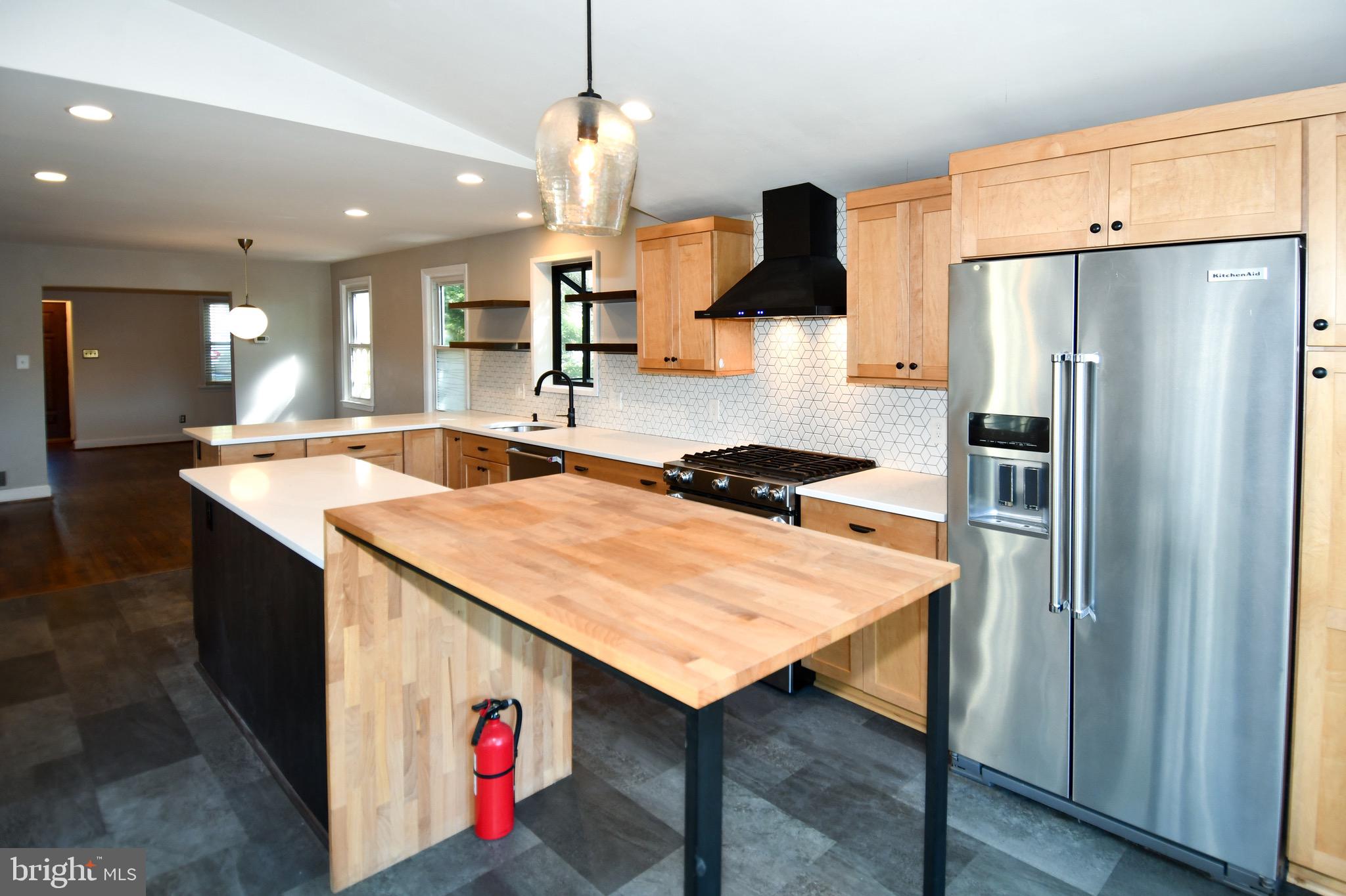 2100 South Quebec Street Arlington, VA 22204 - Photo 14 of 36 a kitchen with stainless steel appliances kitchen island a table chairs in it and wooden floors