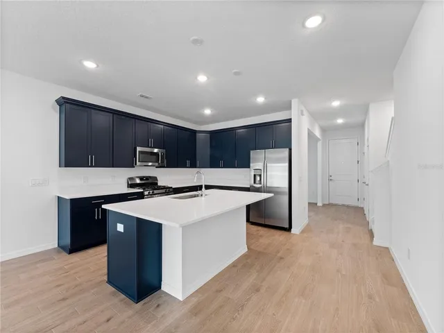 a kitchen with stainless steel appliances a sink stove and refrigerator
