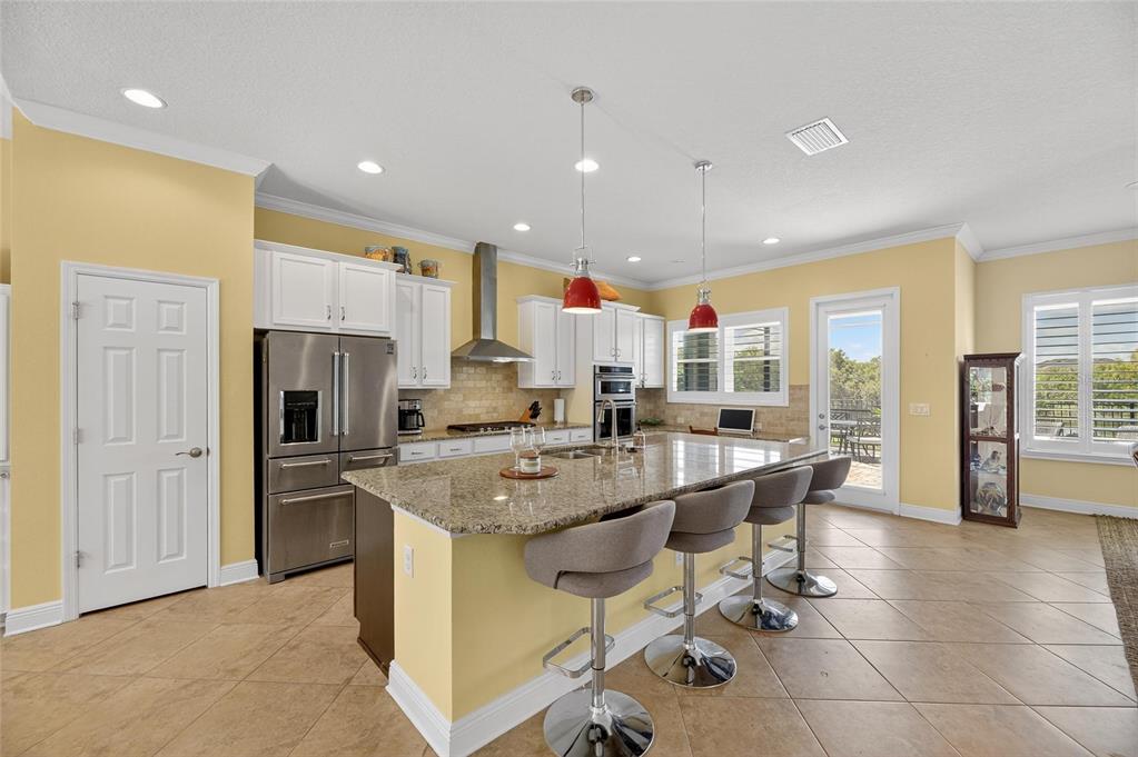 6903 Crestpoint Drive Apollo Beach, FL 33572 - Photo 30 of 95 a kitchen with stainless steel appliances kitchen island granite countertop a sink and cabinets