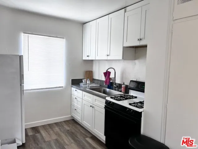 a kitchen with stainless steel appliances a stove a sink and white cabinets