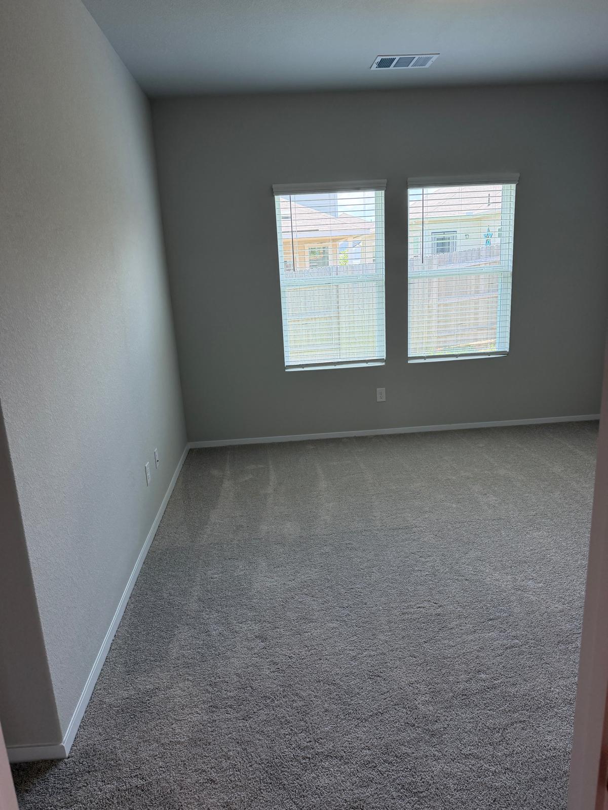 2701 Towy Road Manor, TX 78653 - Photo 21 of 35 Two well-lit windows illuminate this comfortable carpeted primary bedroom.