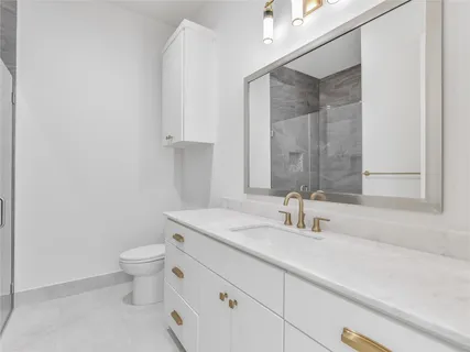 a view of a big room with windows and chandelier fan