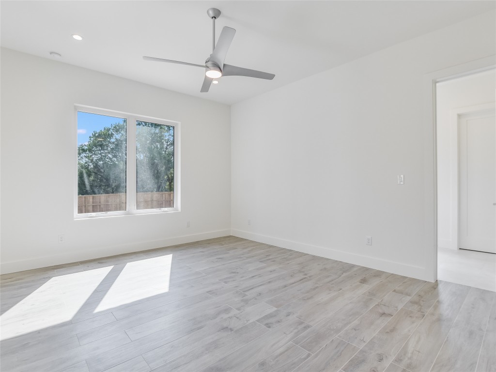 21 Champions Circle Wimberley, TX 78676 - Photo 20 of 27 an empty room with wooden floor fan and windows