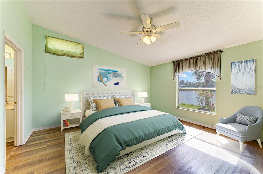 919 Spring Lakes Boulevard Bradenton, FL 34210 - Photo 20 of 43 a bedroom with a bed and a chandelier