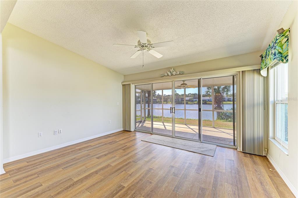 919 Spring Lakes Boulevard Bradenton, FL 34210 - Photo 7 of 43 wooden floor in an empty room with a window