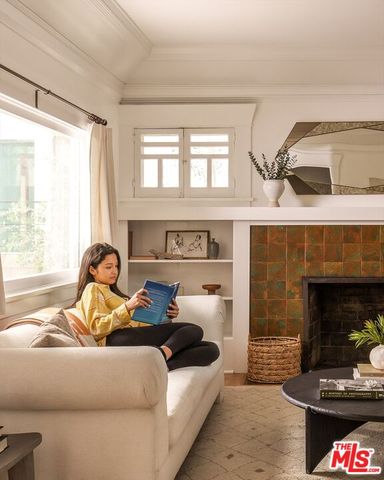 a living room with furniture a fireplace and a window