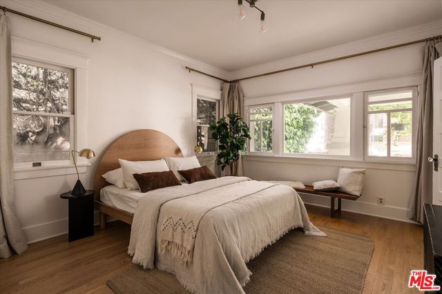 a bedroom with a bed and wooden floor