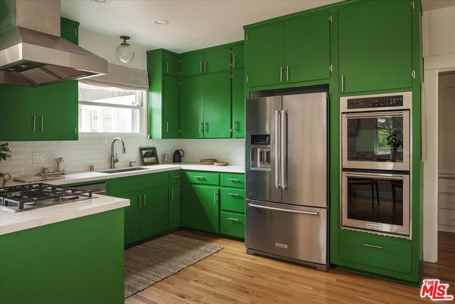 a kitchen with a refrigerator a sink and a stove top oven