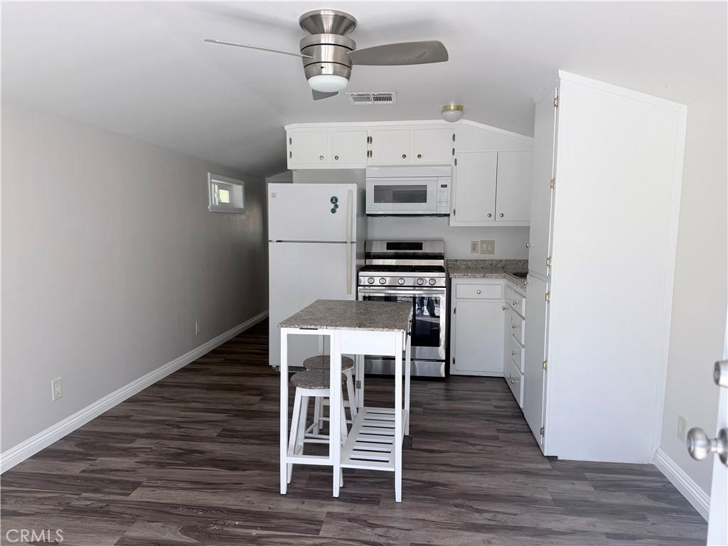 22480 Grand, Unit A Wildomar, CA 92595 - Photo 4 of 7 a kitchen with a stove a refrigerator and wooden floor