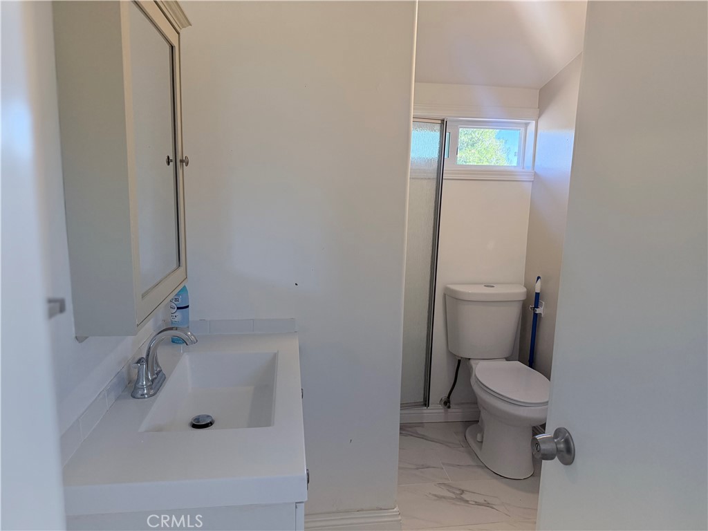 22480 Grand, Unit A Wildomar, CA 92595 - Photo 7 of 7 a white toilet sitting next to a bathroom sink