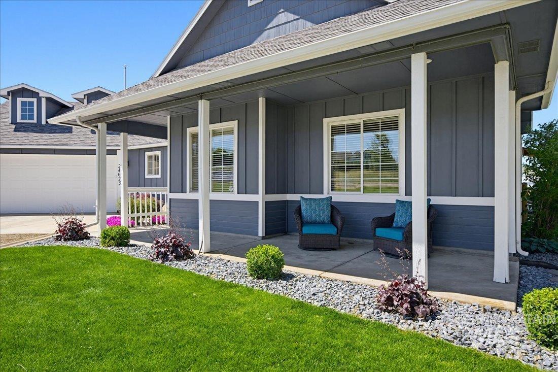 24623 Falcon Lane Caldwell, ID 83607 - Photo 3 of 40 Inviting covered front porch with white columns, board and batten siding, and a concrete patio