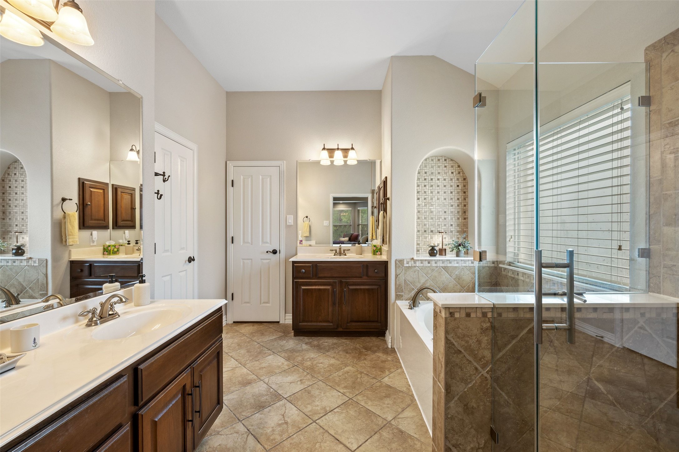 15208 Nightingale Lane Austin, TX 78734 - Photo 20 of 40 Primary Bathroom featuring two vanities, a dual shower head stall shower, and a soaking tub