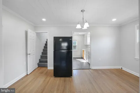 an empty room with wooden floor and staircase