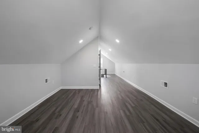 a view of a room with wooden floors and white walls