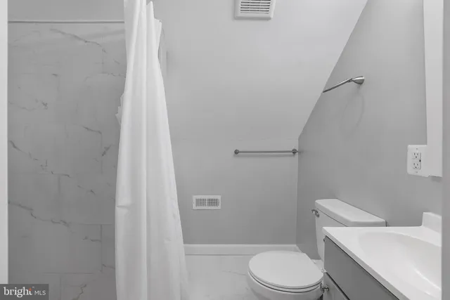 a white toilet sitting next to a shower