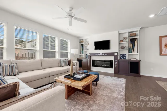 a living room with furniture a fireplace and a flat screen tv